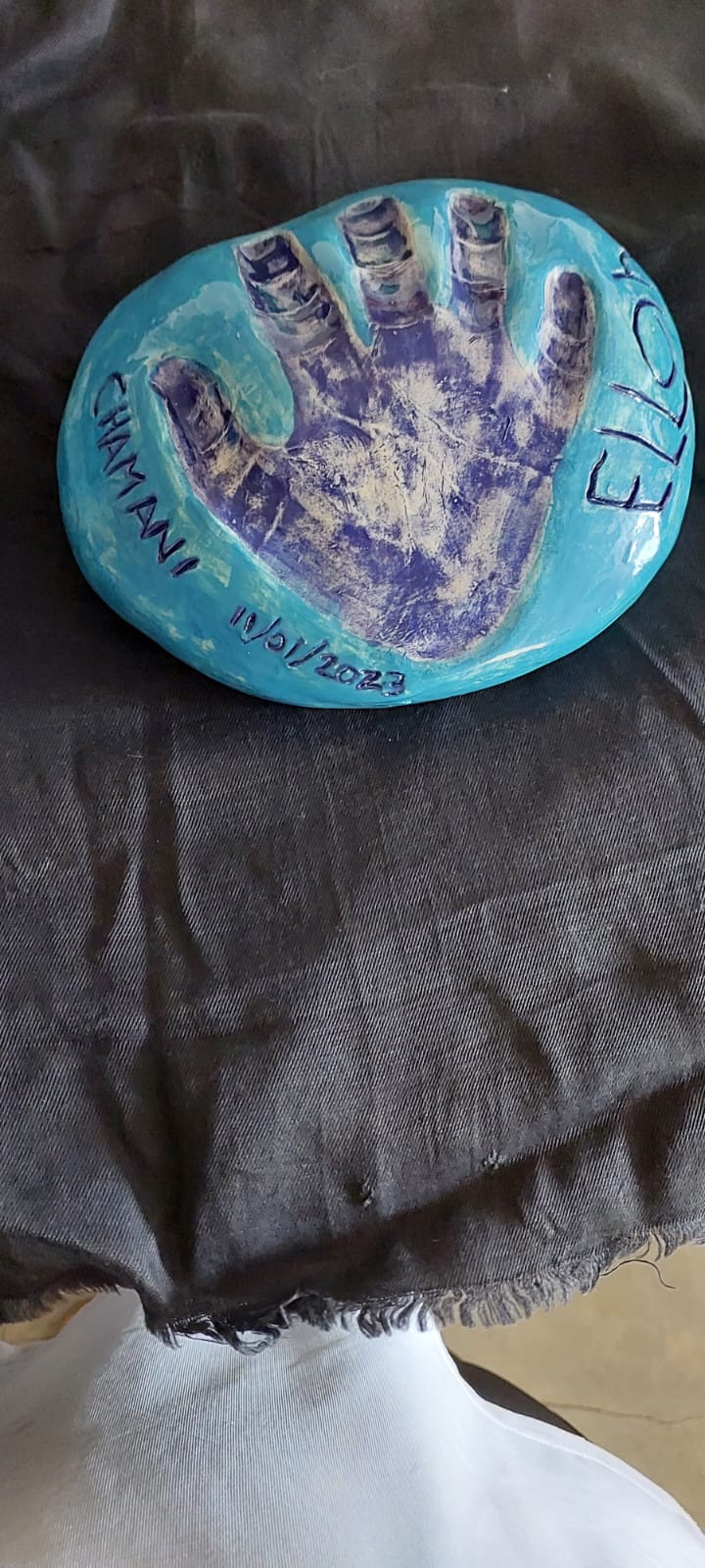 Handprint in clay painted blue by young student at Clay Magic pottery studio.