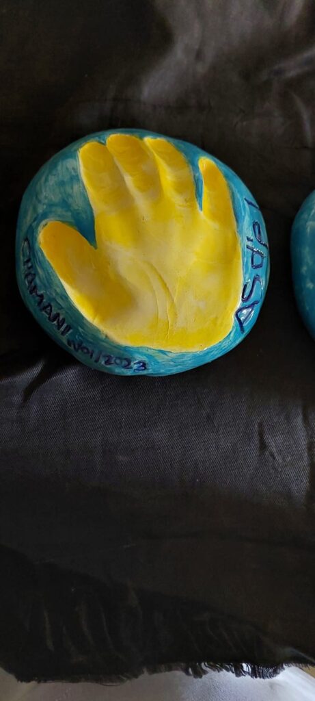 Handprint in clay painted by young student at Clay Magic pottery studio.