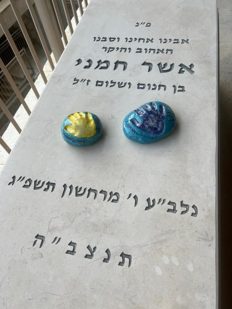 Handprint stones made at Clay Magic pottery studio, on a Gravestone.