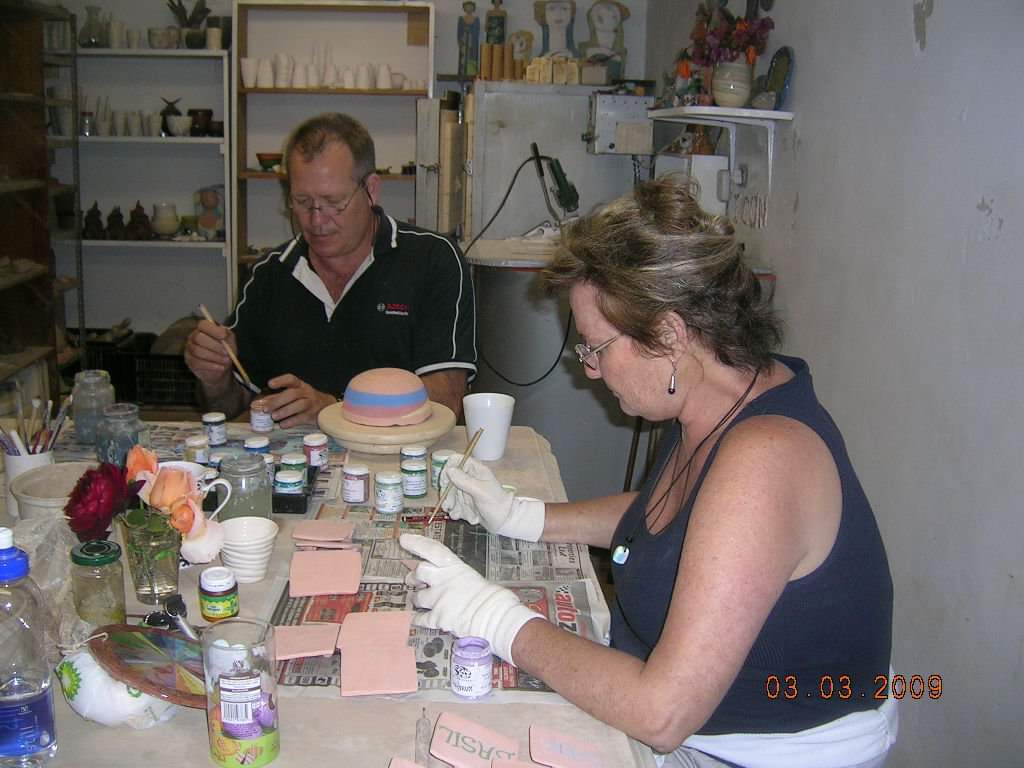 Adult students working alongside each other in a pottery class at Clay Magic studio.