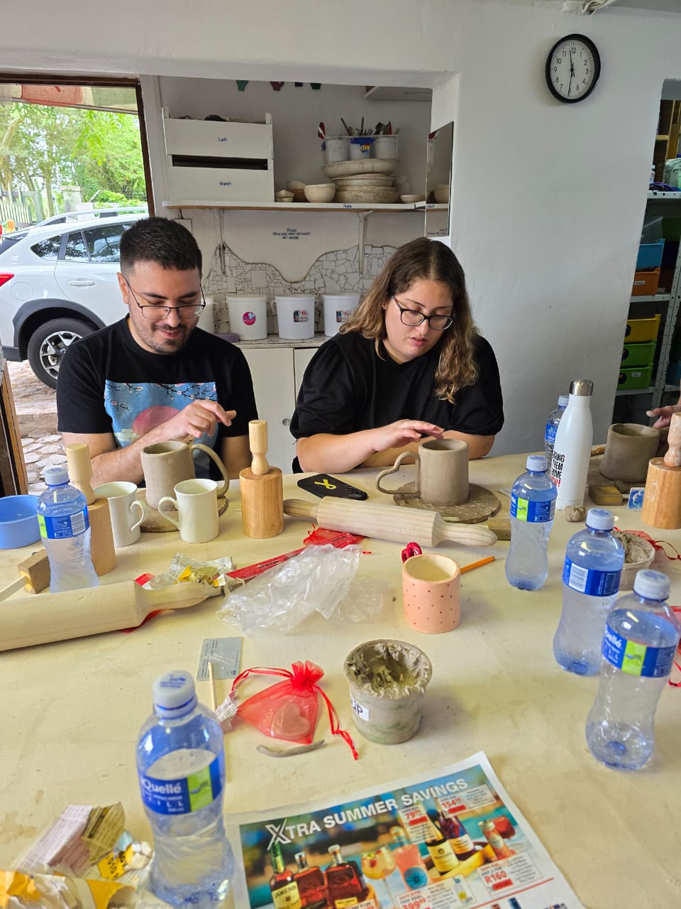 A couple working on their handmade mugs during the pottery workshop.