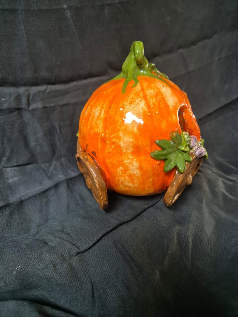 Close-up of a child’s sculpted pumpkin carriage, inspired by fantasy garden themes.