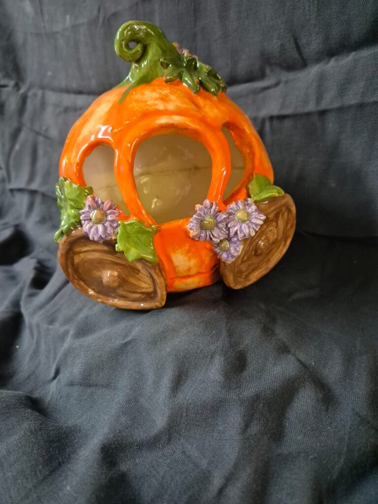 Handmade orange clay pumpkin carriage with vine-like wheels and fairy tale detailing.