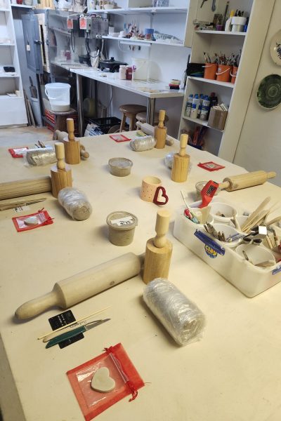 Pottery workshop table set up with clay, tools, and instructions before couples arrive.