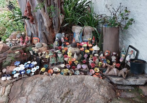 Teacher's handmade pottery displayed in the garden at Clay Magic pottery studio.