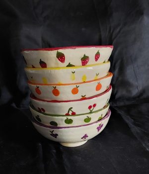 Pottery bowls with fruit painted by a student at Clay Magic studio.
