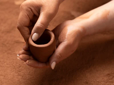 Student smoothing a pinch pot at Clay Magic pottery studio.